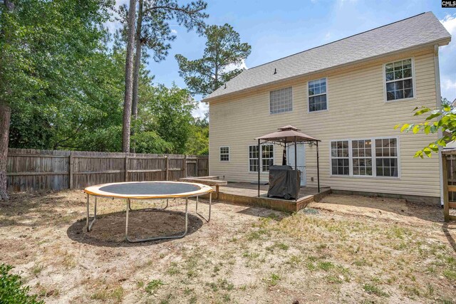 rear view of house featuring a fenced backyard and a wooden deck