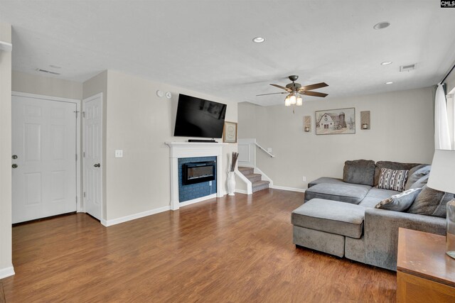 living area with stairway, ceiling fan, wood finished floors, and visible vents