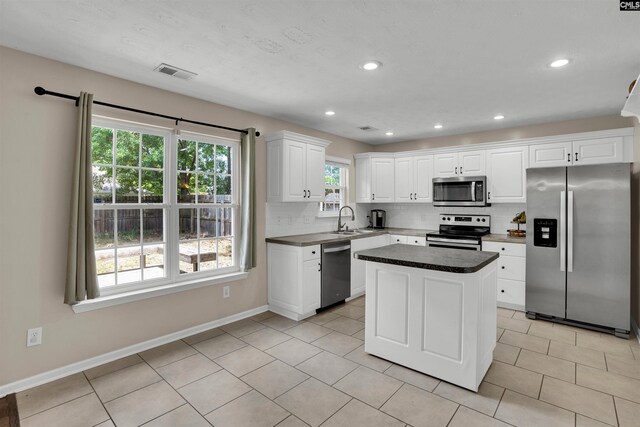 kitchen with visible vents, decorative backsplash, white cabinetry, a sink, and appliances with stainless steel finishes