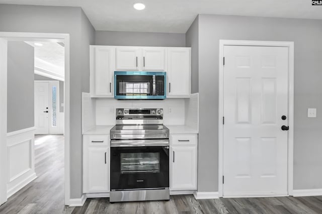 kitchen featuring recessed lighting, light countertops, white cabinetry, dark wood finished floors, and appliances with stainless steel finishes