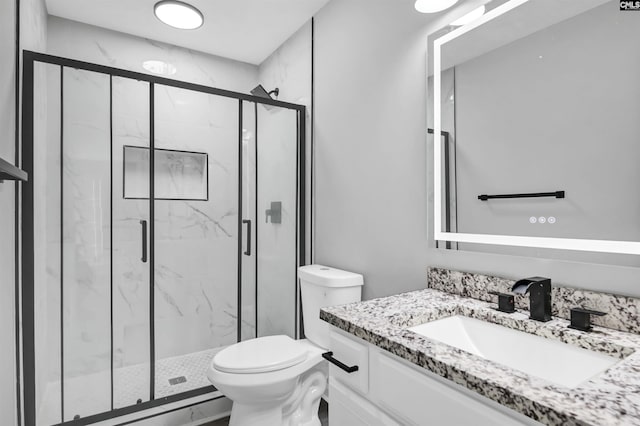 bathroom with vanity, a marble finish shower, and toilet