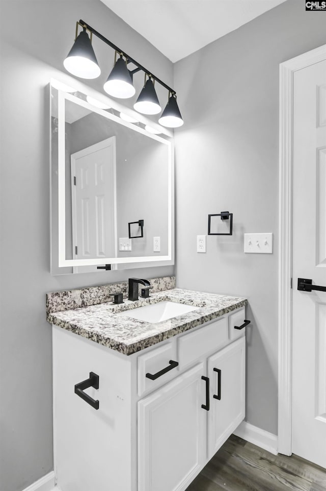 bathroom featuring baseboards, vanity, and wood finished floors