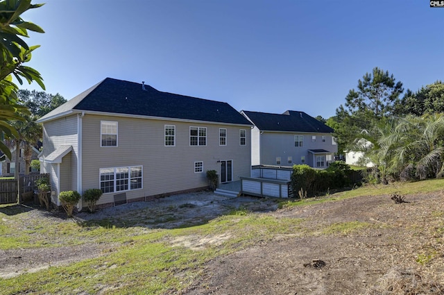 rear view of house featuring fence and a wooden deck