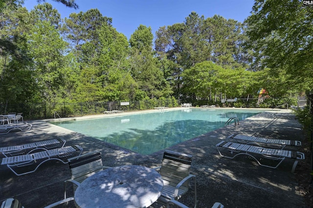 community pool featuring a patio area and fence