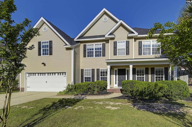 view of front of property with a garage, a front lawn, driveway, and covered porch