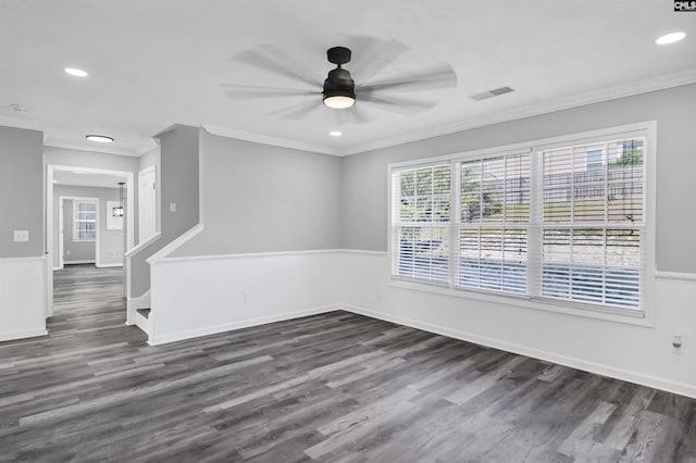 empty room with dark wood-style flooring, visible vents, and ornamental molding