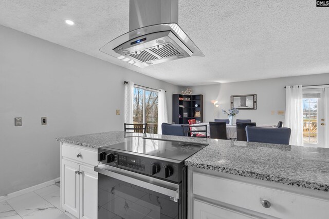 kitchen featuring range with electric stovetop, a textured ceiling, light stone countertops, open floor plan, and white cabinetry