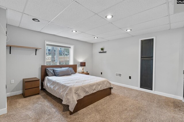 carpeted bedroom featuring baseboards, a drop ceiling, recessed lighting, and visible vents