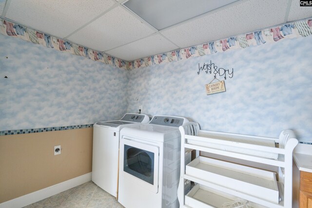 clothes washing area featuring independent washer and dryer, light tile patterned flooring, baseboards, and laundry area