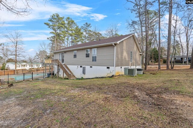 back of house with fence, stairs, a wooden deck, a fenced in pool, and central AC unit