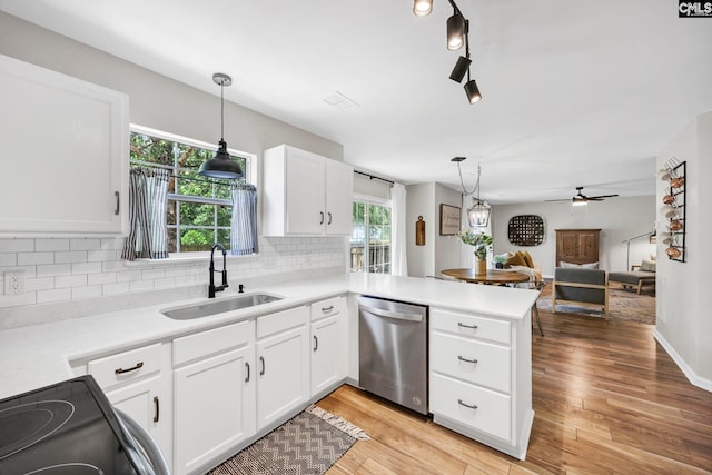 kitchen with electric range, a sink, a peninsula, decorative backsplash, and stainless steel dishwasher