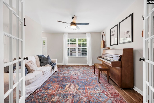 sitting room with french doors, baseboards, ceiling fan, and wood finished floors