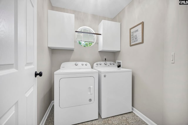 clothes washing area with baseboards, cabinet space, and independent washer and dryer