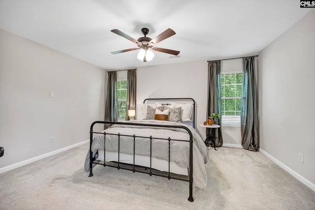 carpeted bedroom with baseboards, ceiling fan, visible vents, and multiple windows