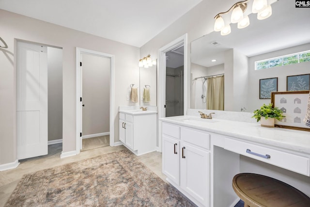 bathroom with a sink, baseboards, visible vents, and two vanities