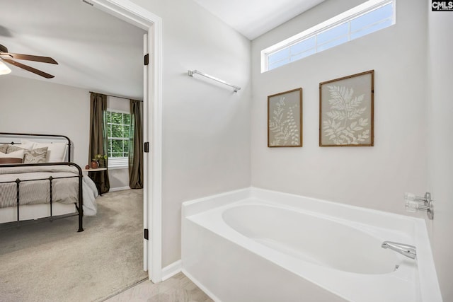 full bathroom with baseboards, a ceiling fan, and a bath