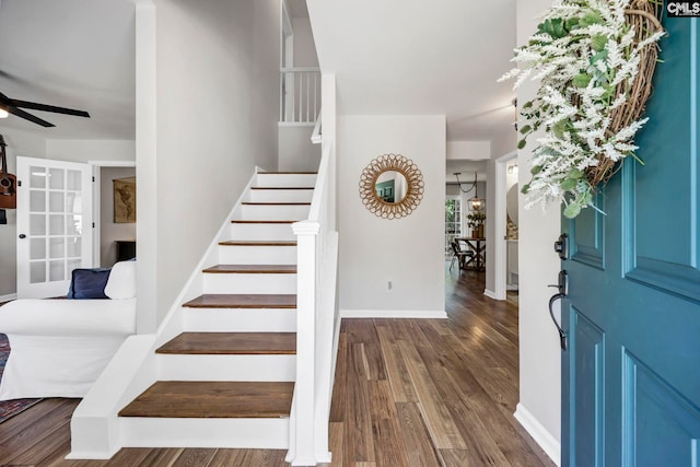 foyer featuring baseboards, a ceiling fan, wood finished floors, and stairway