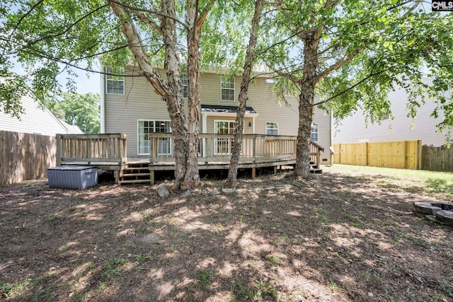 rear view of house featuring a fenced backyard and a wooden deck