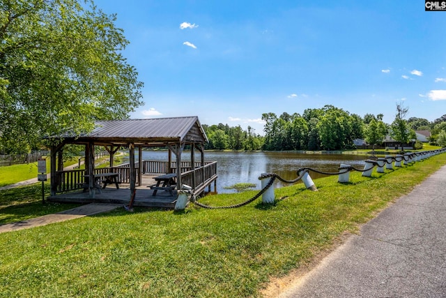 dock area featuring a gazebo, a water view, and a yard