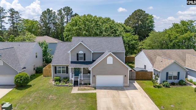 traditional-style home featuring an attached garage, a front lawn, fence, and driveway