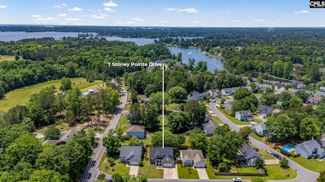 aerial view featuring a water view, a view of trees, and a residential view