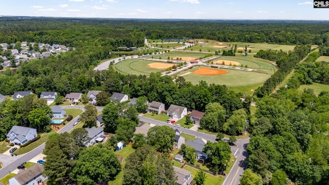 drone / aerial view featuring a residential view and a wooded view