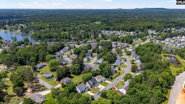 drone / aerial view with a water view, a view of trees, and a residential view