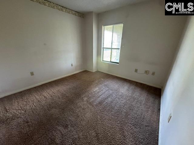 carpeted spare room featuring baseboards