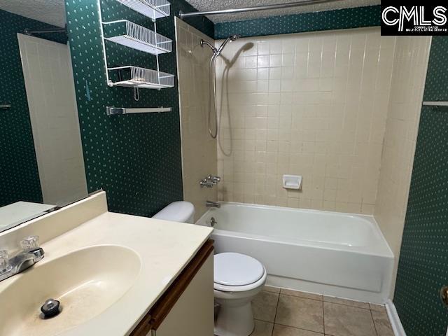 bathroom featuring tile patterned flooring, vanity, toilet, wallpapered walls, and shower / bathing tub combination