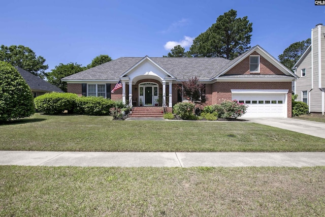 view of front of property featuring brick siding, a garage, a front yard, and concrete driveway