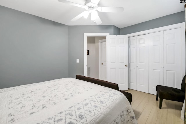 bedroom with a closet, light wood-style flooring, and ceiling fan