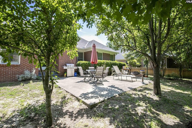 view of patio featuring fence and a grill