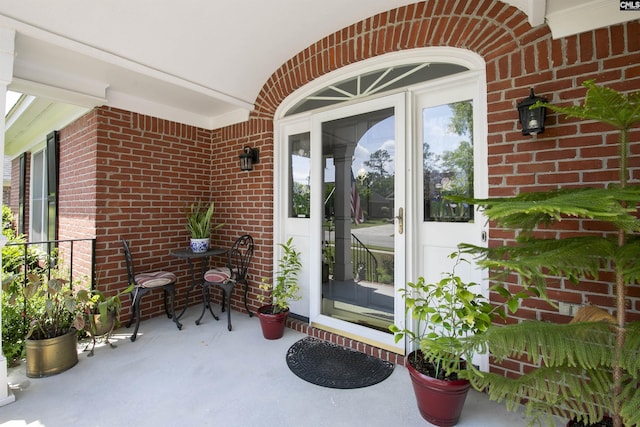 doorway to property with brick siding