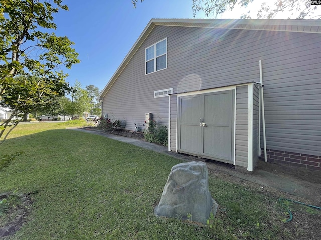 view of home's exterior with a storage unit, an outdoor structure, and a yard