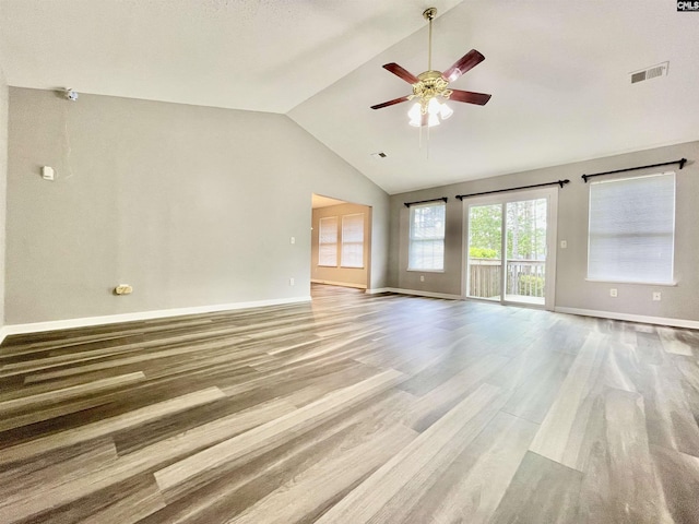 unfurnished living room featuring visible vents, lofted ceiling, wood finished floors, baseboards, and a ceiling fan