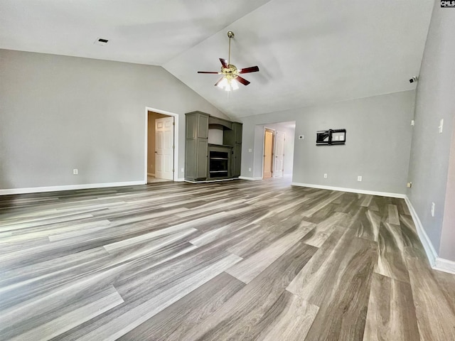 unfurnished living room featuring visible vents, wood finished floors, lofted ceiling, baseboards, and a ceiling fan