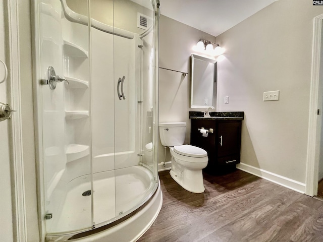 full bathroom with toilet, visible vents, a shower stall, and wood finished floors