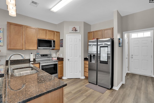 472 Westmoreland Rd, Columbia, SC 29229 - kitchen with appliances with stainless steel finishes, a sink, dark stone countertops, light wood-type flooring, and visible vents