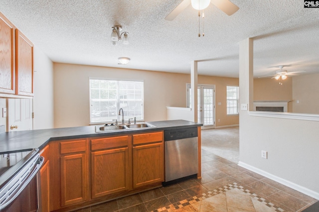 kitchen with a sink, appliances with stainless steel finishes, ceiling fan, and dark countertops