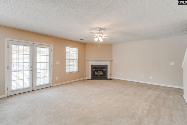unfurnished living room featuring baseboards, a ceiling fan, carpet flooring, and french doors