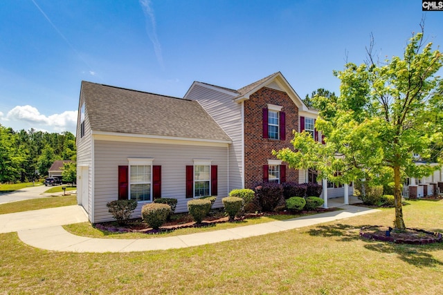 view of front of home featuring a shingled roof, a front lawn, and brick siding