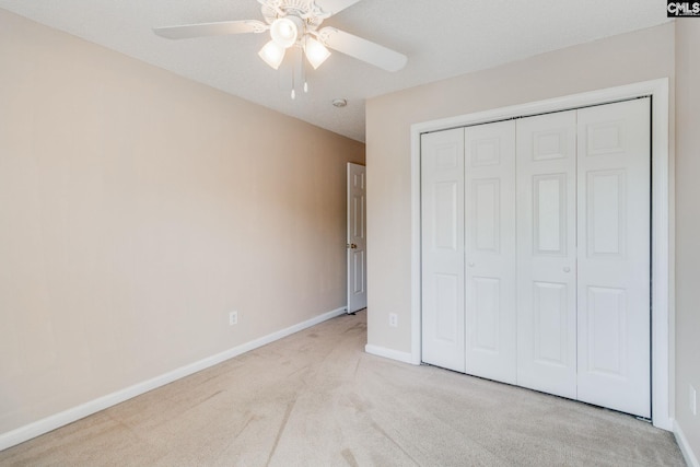 unfurnished bedroom with a closet, baseboards, a ceiling fan, and carpet flooring