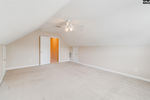 bonus room with baseboards, ceiling fan, vaulted ceiling, and light carpet