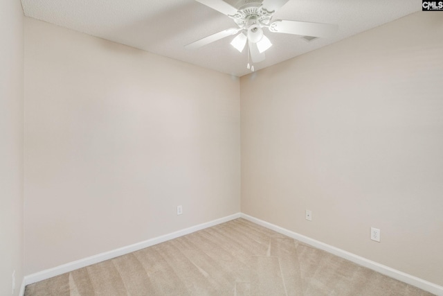 spare room featuring baseboards, ceiling fan, and light carpet