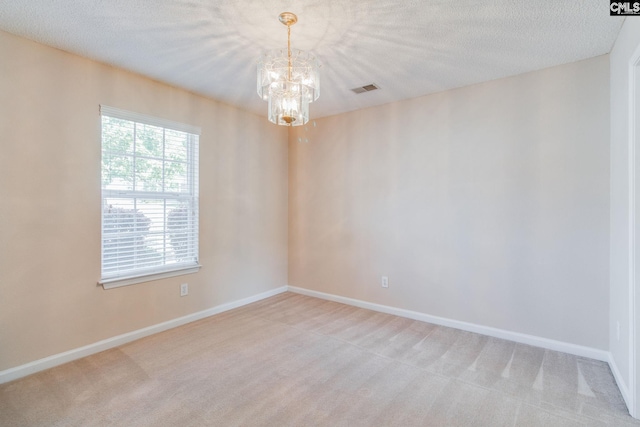 empty room featuring baseboards, visible vents, light carpet, and a chandelier