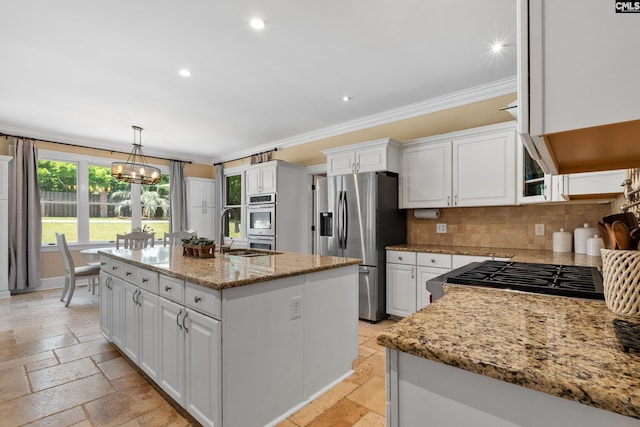 kitchen featuring stone tile flooring, ornamental molding, white cabinetry, and stainless steel appliances