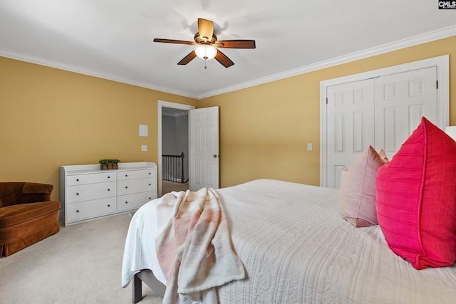 bedroom with crown molding, a ceiling fan, carpet, and a closet