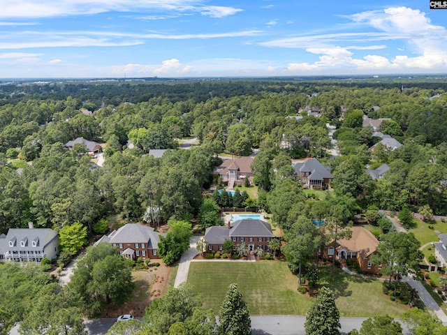 drone / aerial view featuring a residential view and a forest view