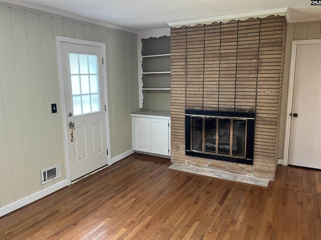 906 Brantley St, Columbia, SC 29210 - unfurnished living room featuring crown molding, a brick fireplace, hardwood / wood-style floors, and visible vents