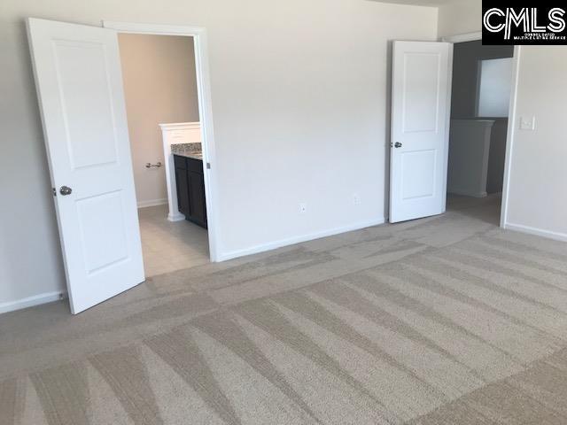 730 Lansford Bay Dr, West Columbia, SC 29172 - unfurnished bedroom with connected bathroom, baseboards, and light colored carpet